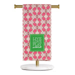 Decorative towel with pink pattern and 'Live Love Play Pickleball' text on a stand.